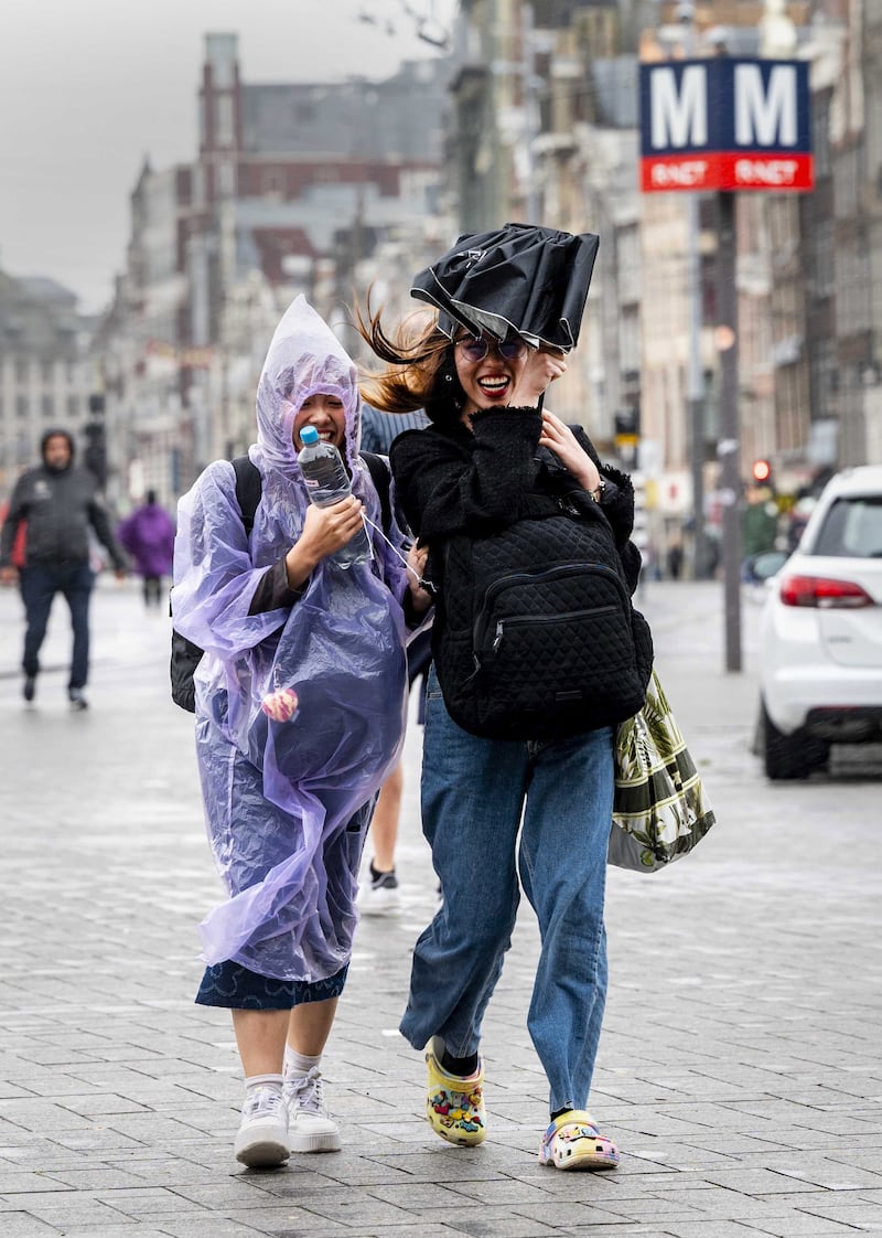 People brave the rough weather in Amsterdam. EPA