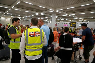 Passengers talk to British government officials at Thomas Cook check-in points at Mallorca Airport after the world's oldest travel firm collapsed stranding hundreds of thousands of holidaymakers around the globe and sparking the largest peacetime repatriation effort in British history, in Palma de Mallorca, Spain, September 23, 2019. REUTERS/Enrique Calvo