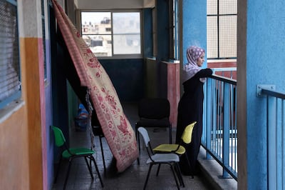 A member from the Abu Ghadyan Palestinian family is pictured on the balcony of a school run by the United Nations Relief and Works Agency for Palestine Refugees (UNRWA) where she will be living temporarily with her relatives, after their home was damaged during the recent Israeli bombing in Gaza City, on May 29, 2021, more than a week after a ceasefire brought an end to 11 days of hostilities between Israel and Hamas.  / AFP / THOMAS COEX
