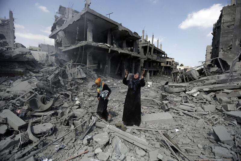 A woman pauses amid destroyed buildings in the northern district of Beit Hanun in the Gaza Strip during a truce on July 26. Mohammed Abed / AFP
