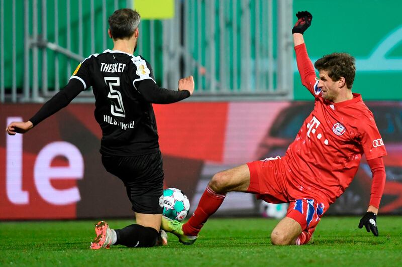 Bayern Munich's Thomas Mueller and Stefan Thesker of Holstein Kiel challenge for the ball. AFP