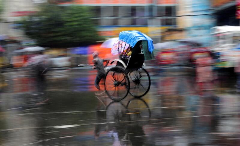 An Indian pulls his rickshaw during continuous rain in Kolkata, India.  EPA