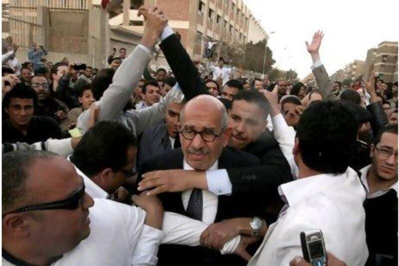 Mohammed ElBaradei, the Egyptian opposition leader and former UN nuclear watchdog chief, is protected on March 19, 2011 as hundreds of Islamists hurled stones and shoes at him as he went to cast his ballot in Cairo in a referendum.