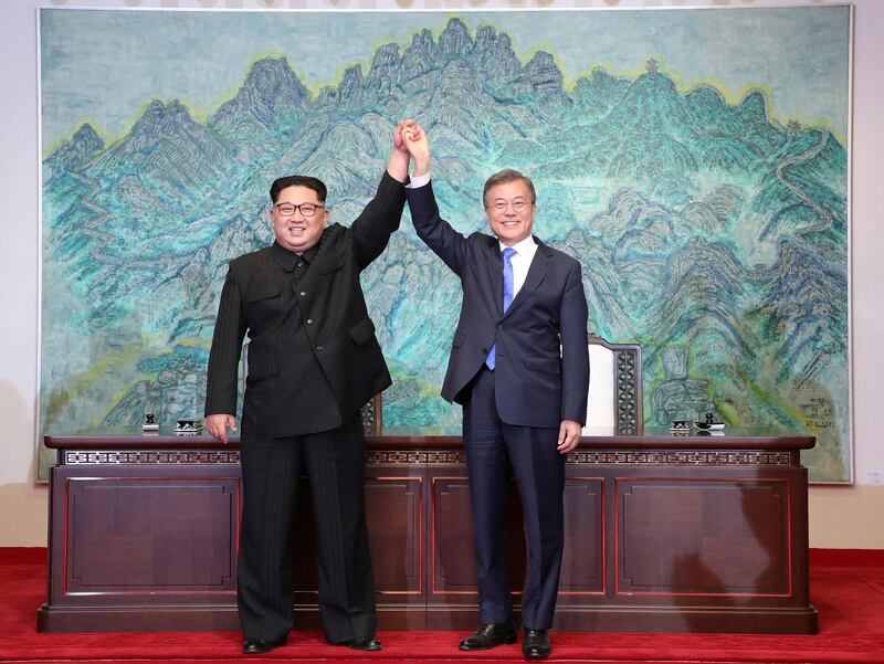 FILE - In this Friday, April 27 file photo, North Korean leader Kim Jong Un, left, and South Korean President Moon Jae-in raise their hands after signing on a joint statement at the border village of Panmunjom in the Demilitarised Zone, South Korea.  North Korea's Foreign Ministry said Saturday May 12, 2018, it will hold a "ceremony" for the dismantling of its nuclear test site on May 23-25 in what would be a dramatic but symbolic event to set up the summit meeting between Kim Jong Un and US President Donald Trump scheduled for next month.(Korea Summit Press Pool via AP, File)