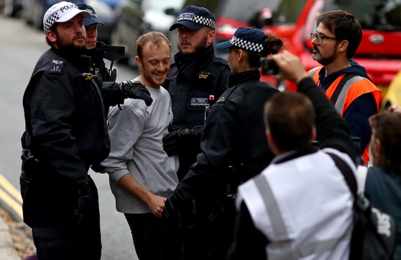 Police officers detain a man outside Lambeth County Court, during a raid on an Extinction Rebellion storage facility, in London, Britain October 5, 2019. REUTERS/Simon Dawson
