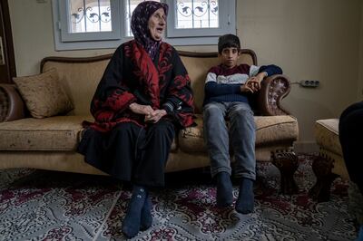 Omar with his grandmother, Nafle Ido, who says the boy saved her and his grandfather from the rubble after getting help once he escaped. Matt Kynaston / The National.