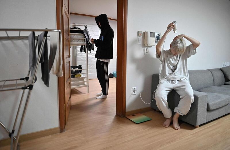 Blitzers member Lee Jun-young, right, drying his hair after getting up, at the band's shared house in Seoul. AFP