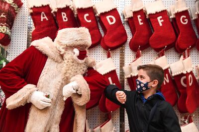 LONDON, ENGLAND - OCTOBER 12: Santa Claus greets Jaythan Corbacho with an elbow bump during the Selfridges 2020 Christmas Shop "Once upon a Christmas" photocall at Selfridges, Oxford Street on October 12, 2020 in London, England. (Photo by Eamonn M. McCormack/Getty Images)