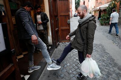 People salute using their feet to avoid contact, after a decree orders for the whole of Italy to be on lockdown in an unprecedented clampdown aimed at beating the coronavirus, in Trastevere area, Roma Italy, March 10, 2020. REUTERS/Guglielmo Mangiapane