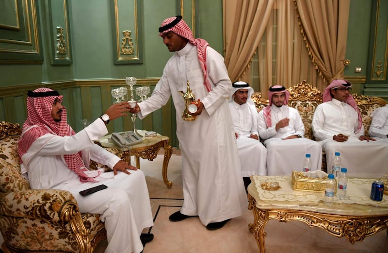 Saudis attend the wedding of a friend at his home in the Red Sea resort of Jeddah on September 6, 2018. It was a Saudi wedding like any other -- clutching a decorative sword, the groom bobbed and swayed in a traditional dance. But there was one striking difference -- a tiny guest list. Weddings in the oil-rich kingdom are typically lavish affairs, with a bulging guest list which is seen both as a social obligation and a symbol of affluence.
 / AFP / Amer HILABI
