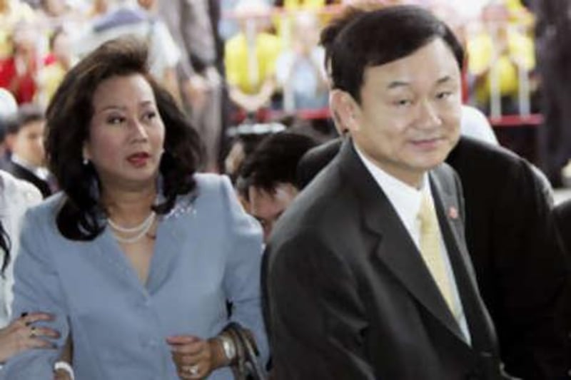 In this July 31, 2008 file photo, deposed Thai Prime Minister Thaksin Shinawatra and his wife Pojaman Shinawatra arrive at criminal court in Bangkok.