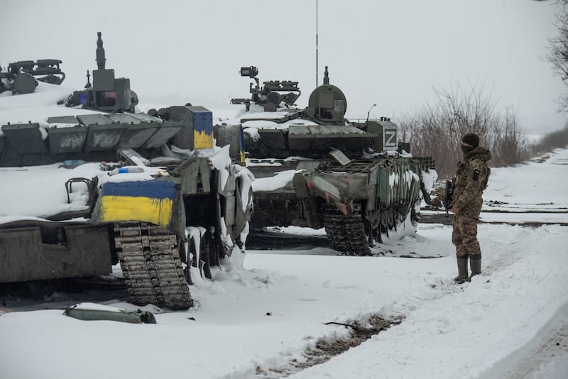A Ukrainian serviceman stands near captured Russian tanks, one painted in the colours of the Ukrainian national flag and the other marked with the letter 'Z' in the north of the Kharkiv region, Ukraine. Reuters