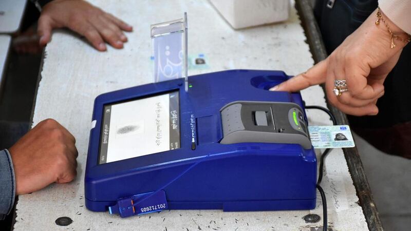 An Iraqi voter has her biometric voting card checked with her fingerprint upon arriving at a poll station for the parliamentary elections in the northern multi-ethnic city of Kirkuk on May 12, 2018, Marwan Ibrahim / AFP