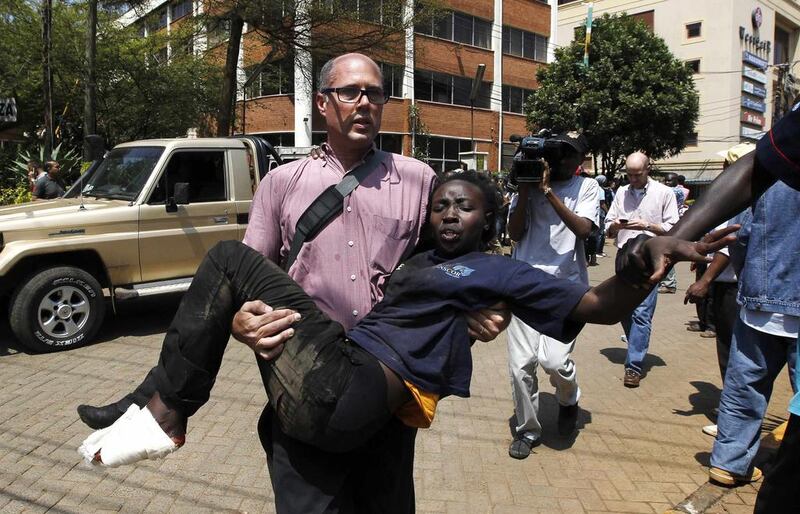 A journalist carries a woman injured during an attack at the upscale Westgate shopping mall in Nairobi on Saturday. Thomas Mukoya / Reuters