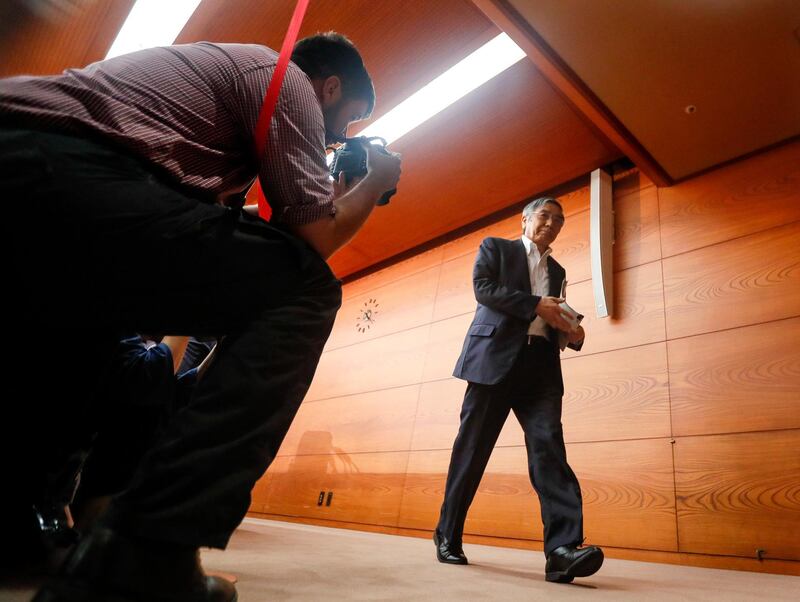 A photographer aims takes a photo of the Governor of Bank of Japan Haruhiko Kuroda in Tokyo. Kimimasa Mayama / EPA