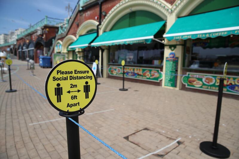 A social distance sign is seen on the seafront at Brighton beach, following the outbreak of the coronavirus disease (COVID-19), Brighton, Britain, May 22, 2020. REUTERS/Peter Cziborra