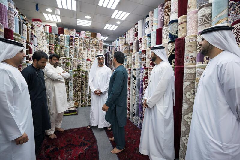 ABU DHABI, UNITED ARAB EMIRATES -  February 22, 2018: HH Sheikh Mohamed bin Zayed Al Nahyan, Crown Prince of Abu Dhabi and Deputy Supreme Commander of the UAE Armed Forces (C), speaks with staff at Al Safa Carpet shop, in the carpet market of the Mina Zayed Port. Seen with HE Jassem Mohamed Bu Ataba Al Zaabi, Chairman of Abu Dhabi Executive Office and Abu Dhabi Executive Council Member (L), HE Mohamed Mubarak Al Mazrouei, Undersecretary of the Crown Prince Court of Abu Dhabi (2nd R), and HH Sheikh Theyab bin Mohamed bin Zayed Al Nahyan, Chairman of the Department of Transport, and Abu Dhabi Executive Council Member (R). 
( Ryan Carter for the Crown Prince Court - Abu Dhabi )
---