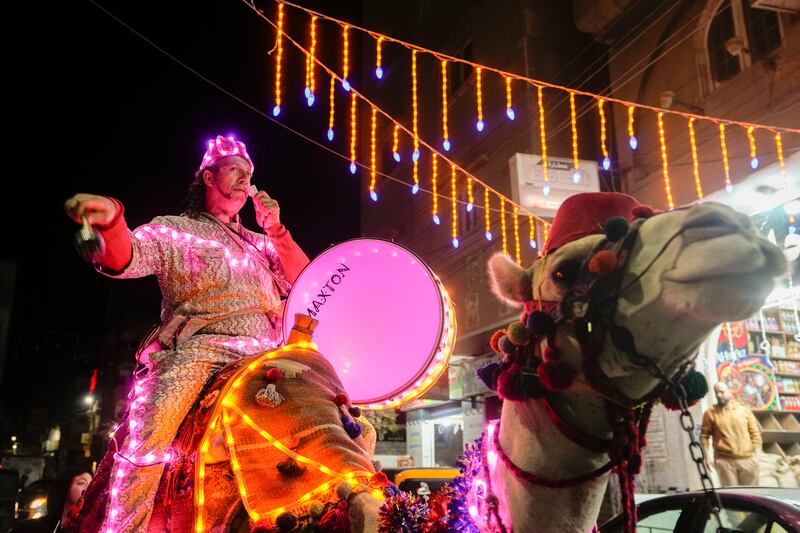 Mohammed El-Dahshan, a 39-year-old "Mesaharati," or dawn caller, rides his camel wrapped with colored led lights to wake Muslims up for a meal before sunrise, during the Islamic holy month of Ramadan, in the Delta city of Dikernis, Egypt, about 93 miles (150 kilometers) north of Cairo. AP