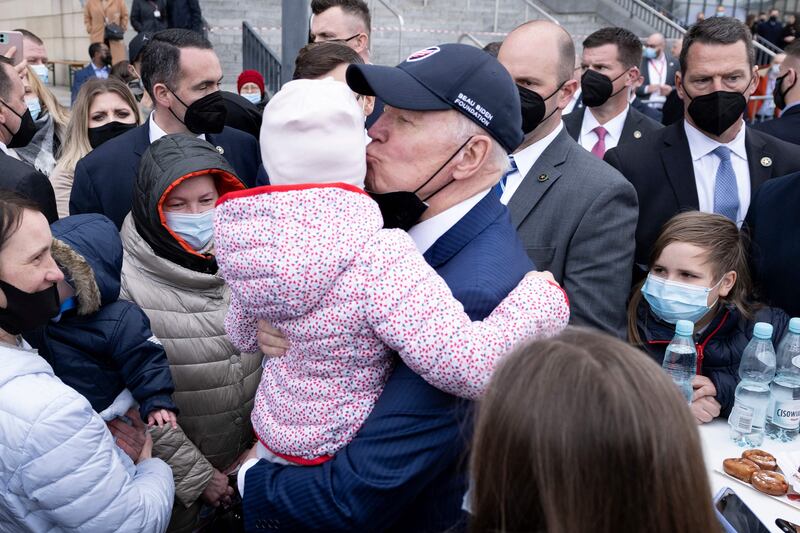 US President Joe Biden kisses a child while meeting refugees of Russia's war with Ukraine at PGE Narodowy Stadium in Warsaw, Poland. AFP