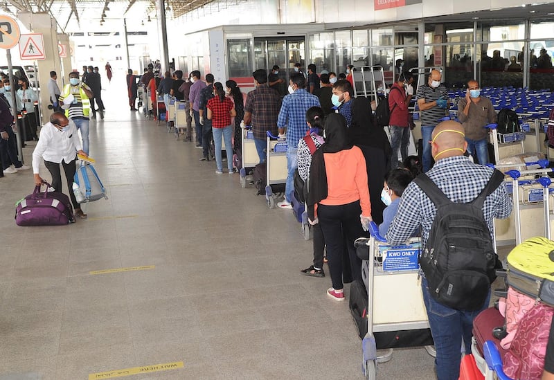 Indian citizens queue at Kuwait International Airport before boarding a repatriation flight to India. AFP