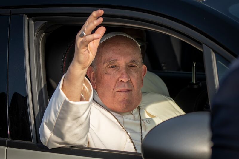 The pontiff waves as he leaves in his vehicle past crowds gathered at the entrance to the airport. AP