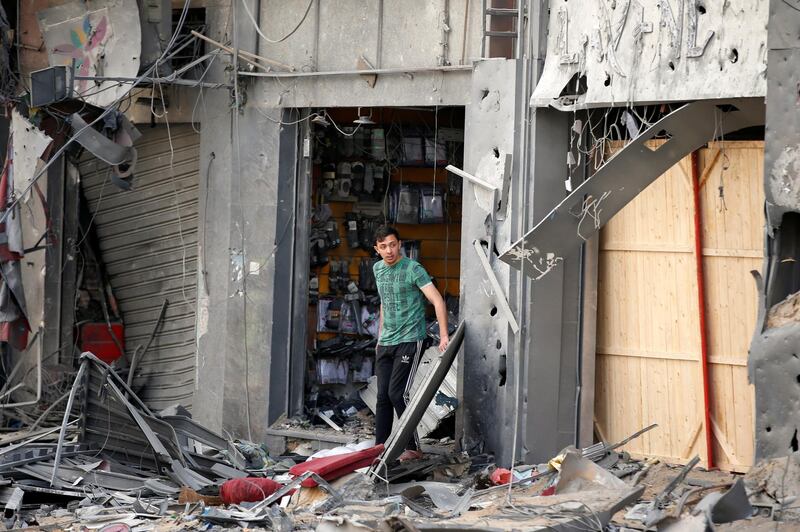 A Palestinian man stands outside a damaged shop in the aftermath of Israeli air strikes that destroyed a tower building in Gaza City. Reuters