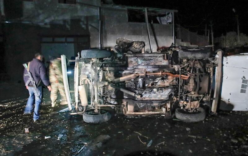 People inspect a car destroyed during a shelling by Azerbaijan's artillery during a military conflict in Stepanakert. AP