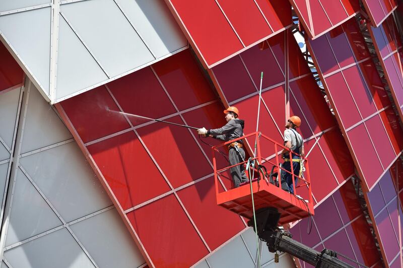 Workers clean the exterior of the Spartak Stadium in Moscow. Yuri Cortez / AFP