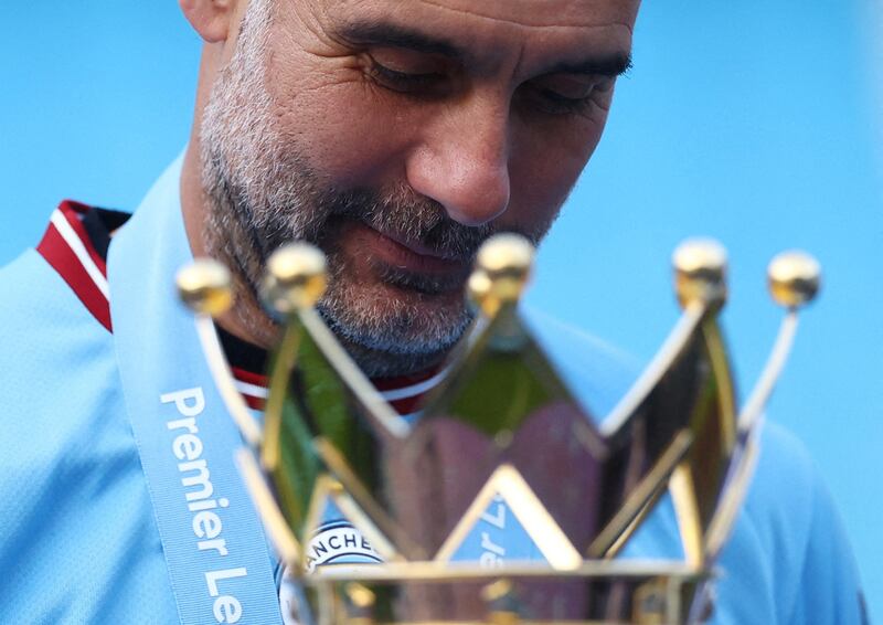 Manchester City manager Pep Guardiola celebrates with the trophy after winning the Premier League. Reuters
