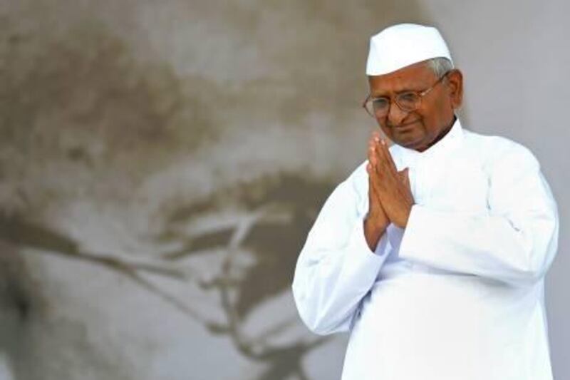 Anti-corruption activist Anna Hazare gestures to supporters as he walks on-stage to break his fast on the 13th day of his hunger strike at the Ram Lila grounds in New Delhi, on August 28, 2011. Indian hunger-striker Anna Hazare, who has led a campaign for a new anti-corruption law, ended his nearly two-week fast August 28 after forcing a weakened government to agree to his demands. AFP PHOTO/Sajjad HUSSAIN