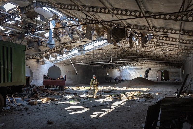 A Ukrainian army officer inspects a grain warehouse shelled by Russian forces in May 2022 near Novovorontsovka, Kherson. Getty Images
