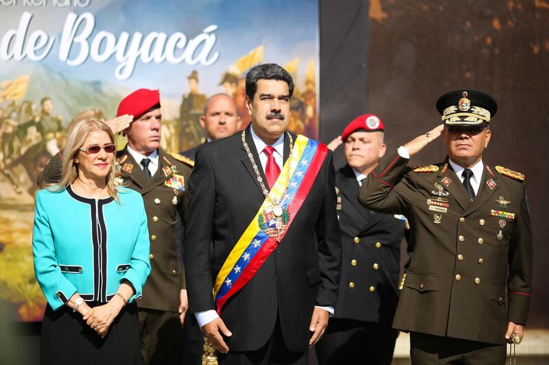 epa07761384 A handout photo made available by the Miraflores Press Office shows Venezuelan President Nicolas Maduro (C), and his wife, Cilia Flores (L), during an act of government in Caracas, Venezuela, 07 August 2019. According to media reports, Maduro decided to suspend the dialogue process he is carrying out with the opposition at the behest of Norway in Barbados, due to the support that the head of Parliament Juan Guaido has shown for the total blockade of Venezuelan state assets in the United States.  EPA/MIRAFLORES PRESS / HANDOUT  HANDOUT EDITORIAL USE ONLY/NO SALES