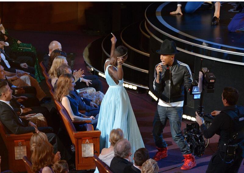 Lupita Nyong’o, left, dances along with Pharrell Williams during his performance of Happy. John Shearer / Invision / AP