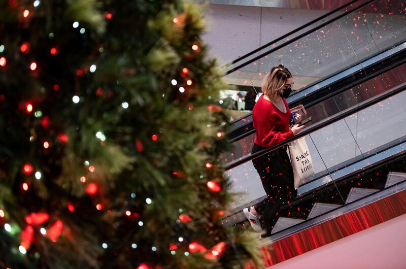 A shopper rides the escalator next to a giant Christmas tree at a mall in Ottawa, Ontario. The Canadian Press via AP