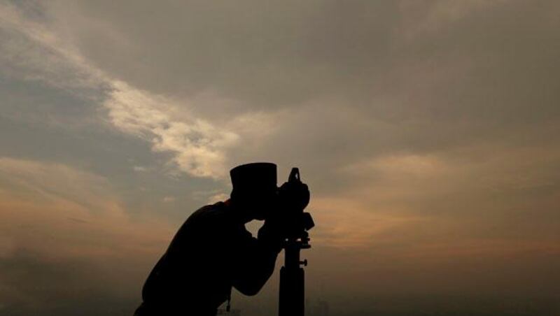 An unidentified official of Malaysia's Islamic authority uses a telescope to perform "Rukyah," the sighting of the new moon to determine the beginning of the holy fasting month of Ramadan at KL Tower, Kuala Lumpur, Malaysia, July 8, 2013. Muslims around the world will start observing Ramadan, the holiest month in Islamic calendar this week. (AP Photo/Daniel Chan)
