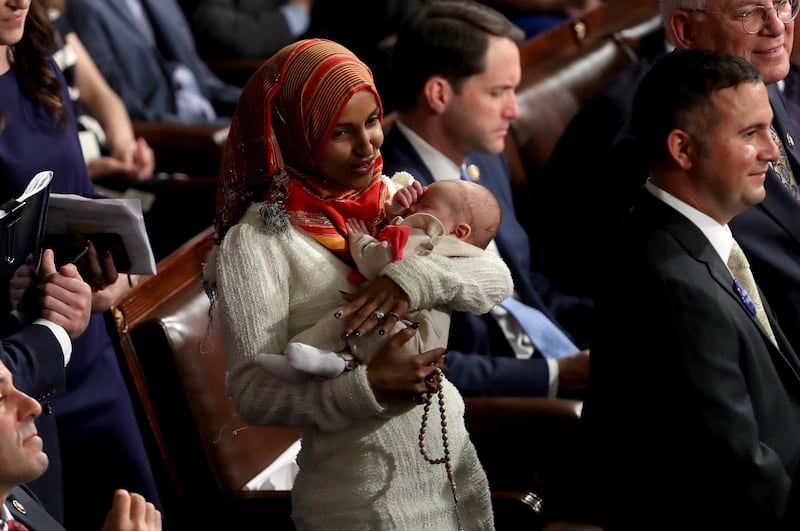 Representative-elect Ilhan Omar holds a baby during a ceremony for the opening of the 116th Congress in the House Chamber. Bloomberg