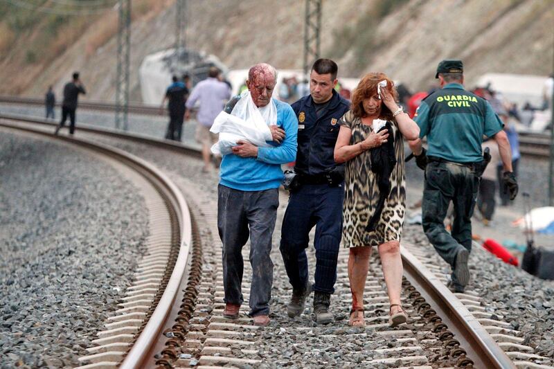 Victims are helped by rescue workers after a train crashed near Santiago de Compostela, northwestern Spain, July 24, 2013. At least 56 people died after a train derailed in the outskirts of the northern Spanish city of Santiago de Compostela, the head of Spain's Galicia region, Alberto Nunez Feijoo, told Television de Galicia.  MANDATORY CREDIT.   REUTERS/Xoan A. Soler/Monica Ferreiros/La Voz de Galicia  (SPAIN - Tags: DISASTER TRANSPORT) SPAIN OUT. NO COMMERCIAL OR EDITORIAL SALES IN SPAIN. MANDATORY CREDIT *** Local Caption ***  PDH704_SPAIN-TRAIN-_0724_11.JPG