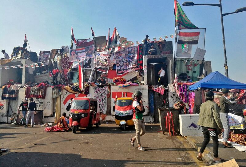 Anti-government protesters sit-in on barriers set up by security forces to close a bridge leading to the Green Zone government areas during ongoing protests, in Baghdad, Iraq. AP Photo