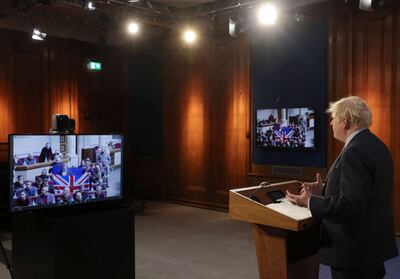 Mr Johnson speaks by video link from Downing Street as a British flag is held up at the Ukrainian end. EPA 