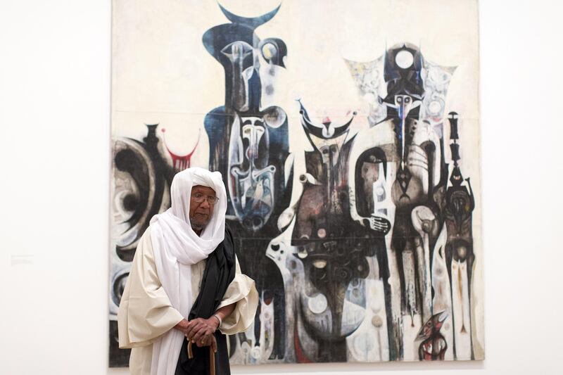 Sudanese artist Ibrahim El-Salahi poses for a photograph in front of his painting entitled "Reborn Sounds of Childhood Dreams" at the Tate Modern in London on July 1, 2013.  AFP PHOTO/JUSTIN TALLIS - ��� RESTRICTED TO EDITORIAL USE, MANDATORY MENTION OF THE ARTIST UPON PUBLICATION, TO ILLUSTRATE THE EVENT AS SPECIFIED IN THE CAPTION ��� (Photo by JUSTIN TALLIS / AFP)