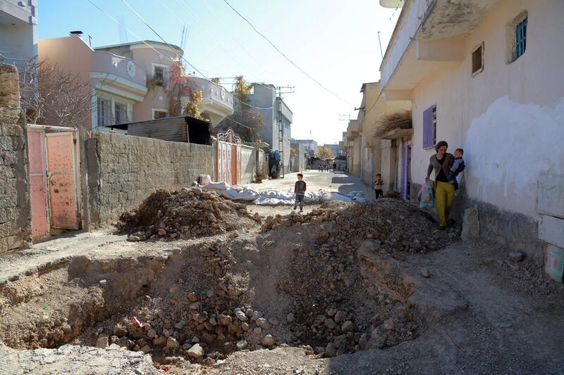 People walk through the destroyed barricades set up by the militants of the Kurdistan Workers' Party, or PKK, in Nusaybin, Turkey on December 25, 2015. Murat Bay / AP Photo