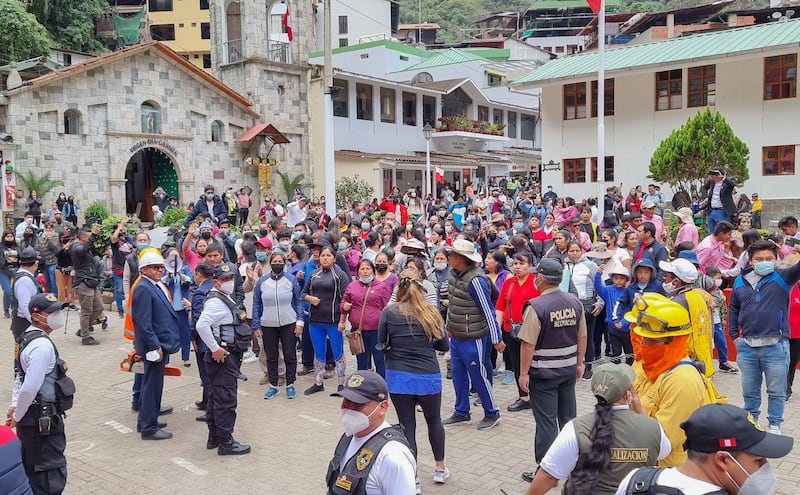 Peruvian and foreign tourists along with tourism workers gather in the streets of the Machu Picchu town. AFP