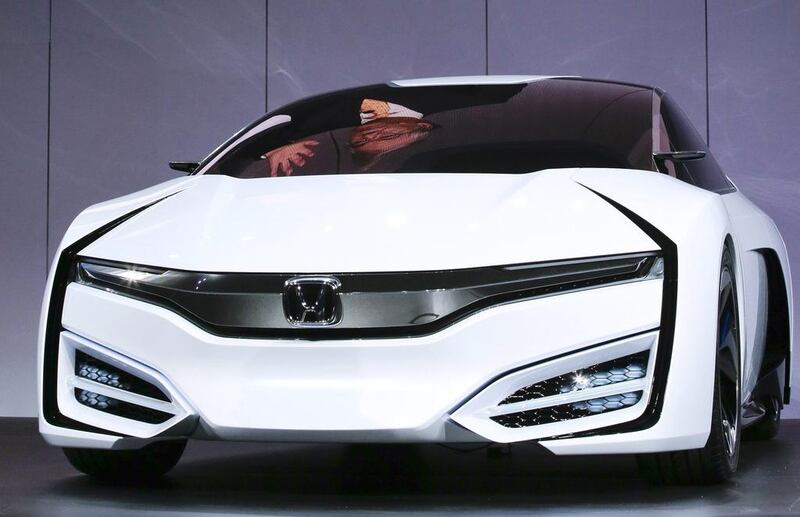 Tetsuo Iwamura, the president and chief executive of American Honda Motor Co, is reflected in a window as he talks about the Honda FCEV Concept during its debut at the Los Angeles Auto Show. AP Photo/Chris Carlson