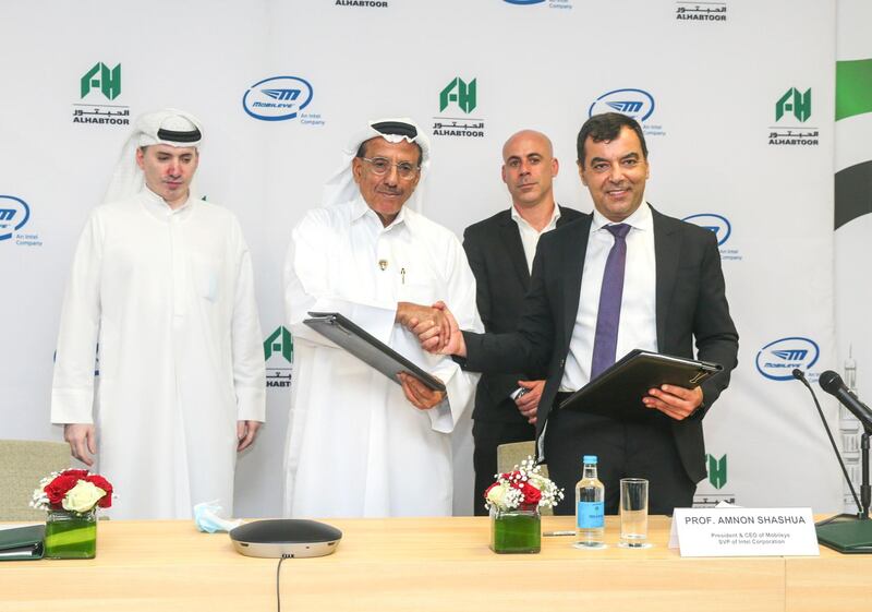 Khalaf Ahmad Al Habtoor (second from left), founding chairman of Al Habtoor Group, shaking hand with Amnon Shashua, chief executive of Mobileye, after signing the pact. Courtesy Al Habtoor Group