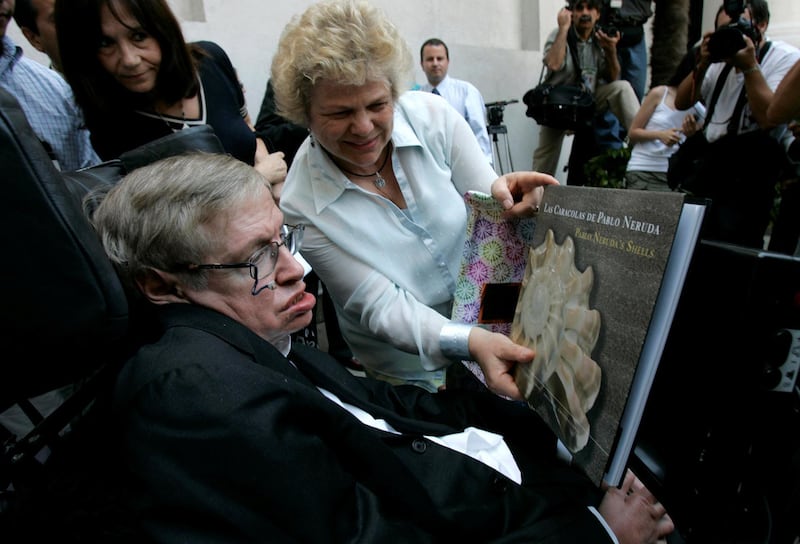 British physicist Stephen Hawking looks at a book of Chile's Nobel Laureate Pablo Neruda after a meeting with Chile's President Michelle Bachelet (unseen) at the Presidential Palace in Santiago on January 17, 2008. Victor Ruiz Caballero / Reuters