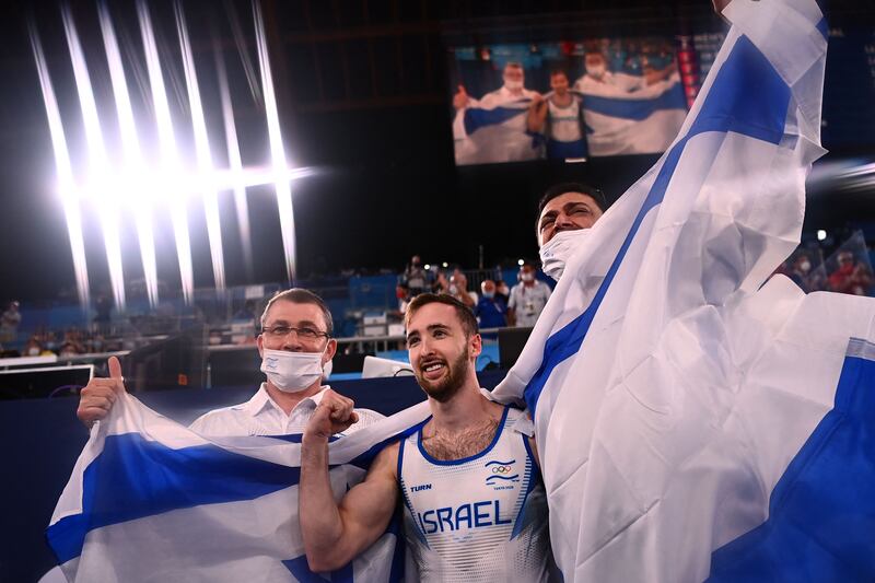 Israel's Artem Dolgopyat (C) celebrates with his team after winning the floor event of the artistic gymnastics men's floor exercise final.