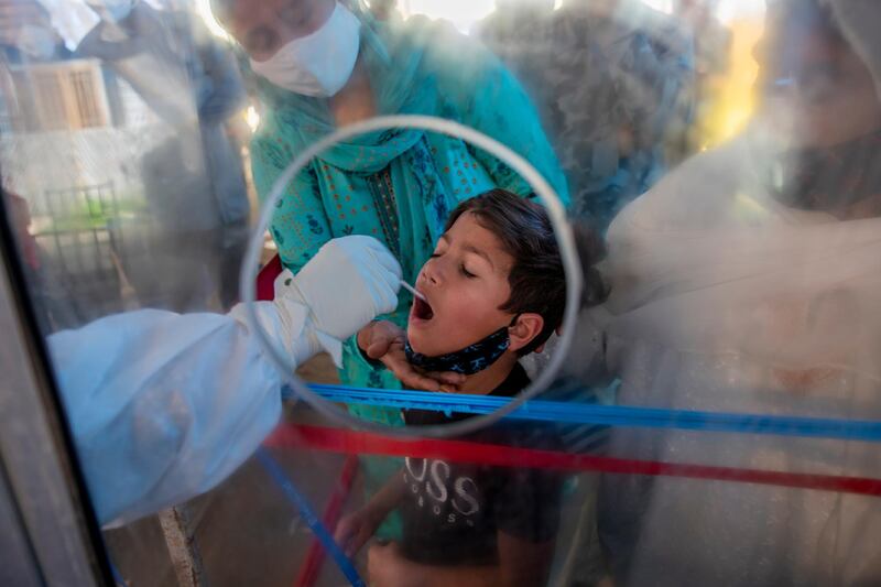 A health worker takes a mouth swab sample of a boy to test for Covid-19 in Srinagar, in Indian-controlled Kashmir.