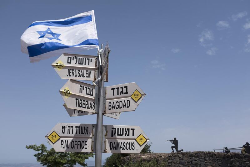 GOLAN HEIGHTS - MAY 10:  (ISRAEL OUT)  A silhouette sculpture of an Israeli soldier standing guard is seen next  to a signs pointing out distance to different cities on Mount Bental next to the Syrian border on May 10, 2018 in the Israeli-annexed Golan Heights. Some 20 rockets were fired at Israeli military bases by Iranian forces from southern Syria just after midnight on Thursday, sparking the largest ever direct clash between Jerusalem and Tehran, with Israeli jets targeting numerous Iranian-controlled sites across Syria. On Monday  U.S. President Donald Trump pulls out of the Iran deal.  (Photo by Lior Mizrahi/Getty Images) *** BESTPIX ***