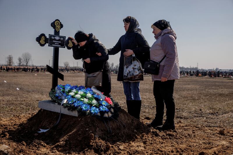 Family members of Borys Romanchenko attend the funeral of the Holocaust survivor in Kharkiv, Ukraine. Romanchenko was killed by Russian shelling, aged 96. Reuters