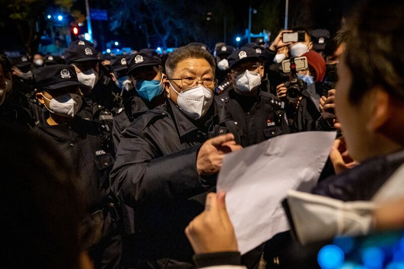 An official speaks with a demonstrator holding a blank sign, during a protest in Beijing. Bloomberg